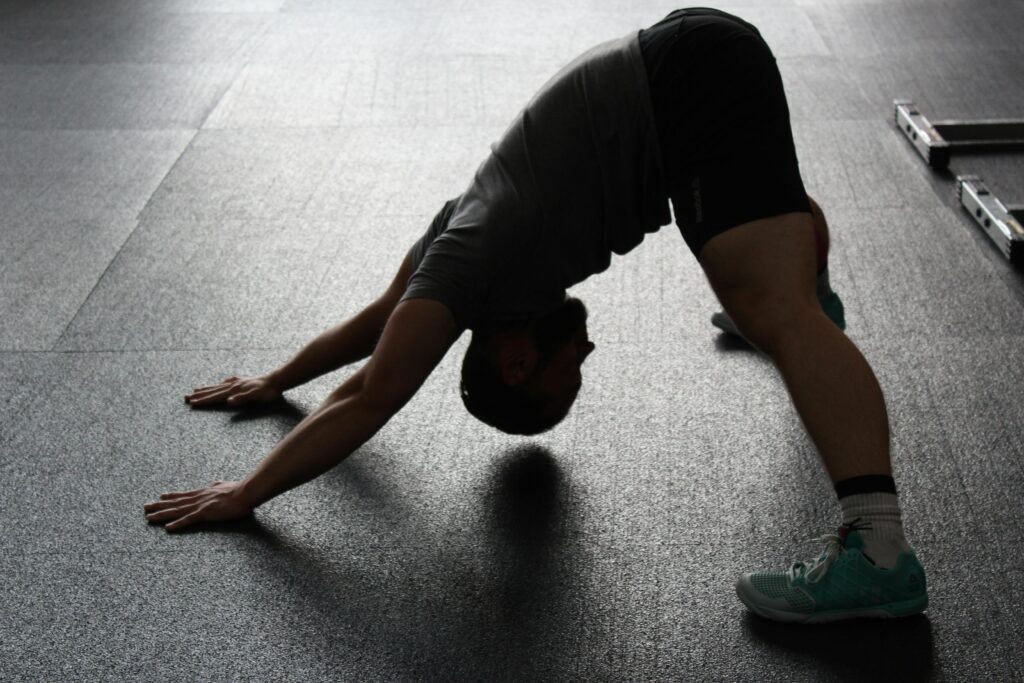 Silhouette of a man stretching indoors, showcasing fitness and flexibility.